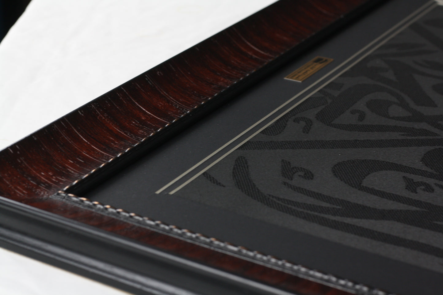 Close-up of a black leather-bound book with embossed design on a white background